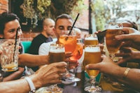 a group of people toasting with beer glasses